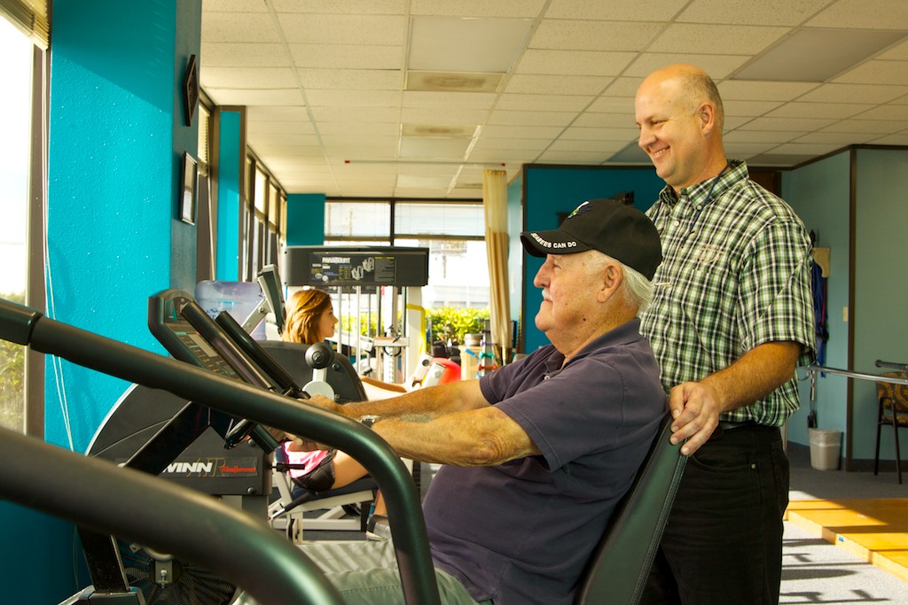 Shull Physical Therapy gym — therapist working with patient on exercise equipment